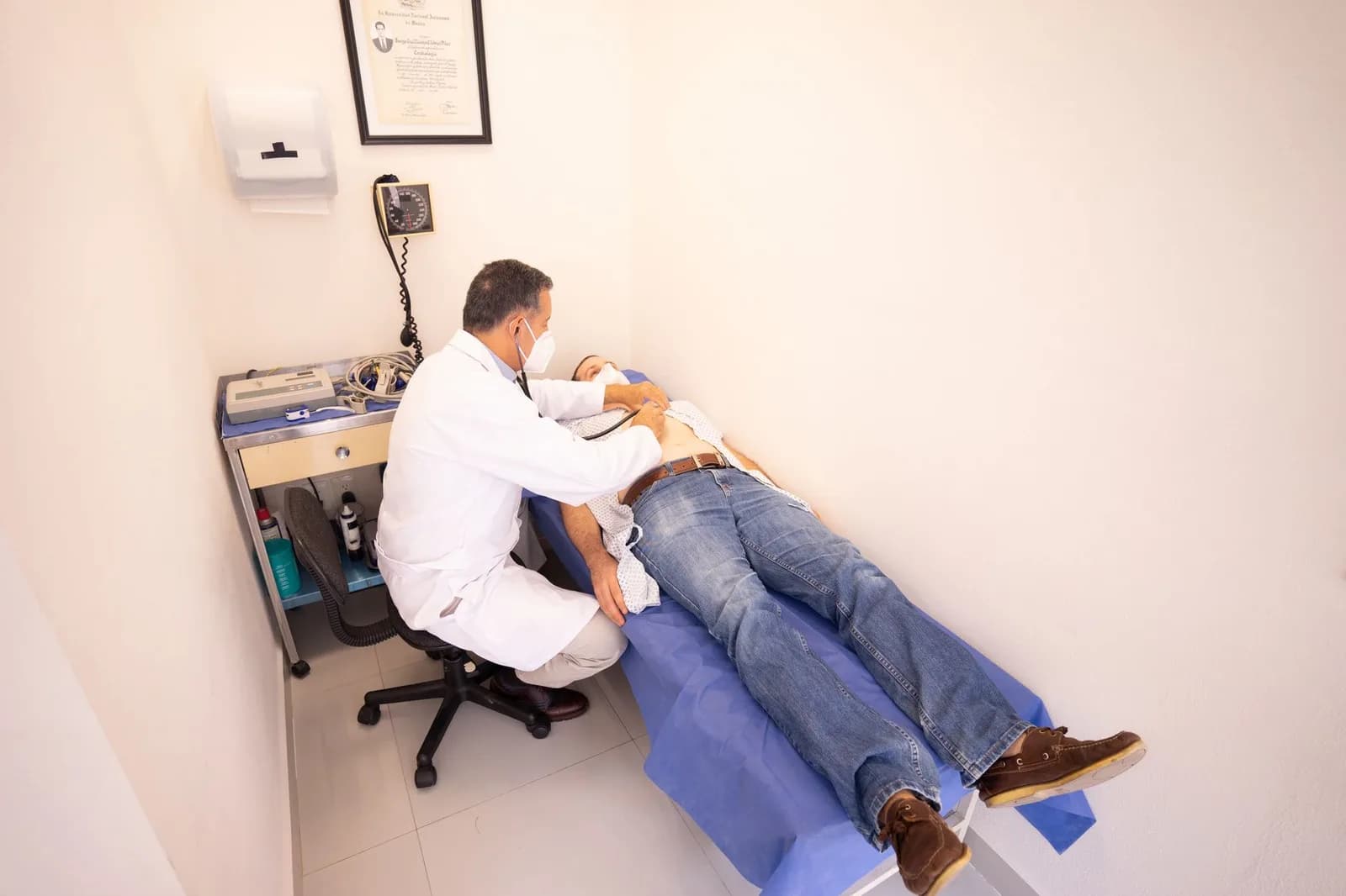 Profissional de saúde examina um paciente com estetoscópio em sala de consulta