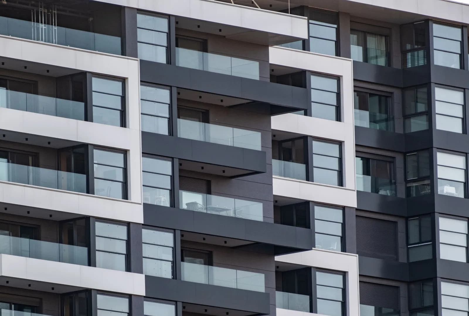 Fachada de prédio residencial moderno, com varandas de vidro