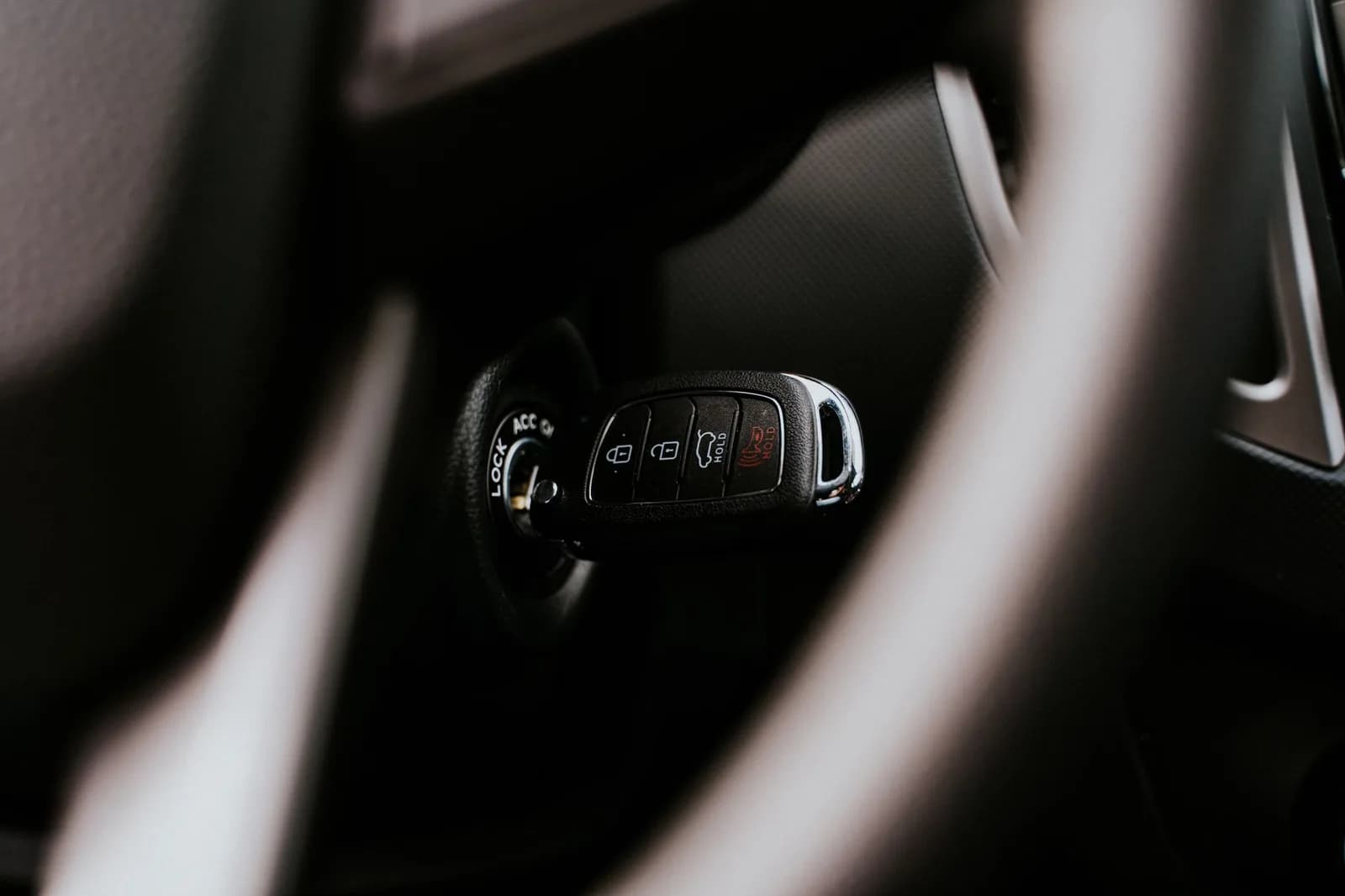 Chave inserida na ignição de um carro, com o volante ao fundo