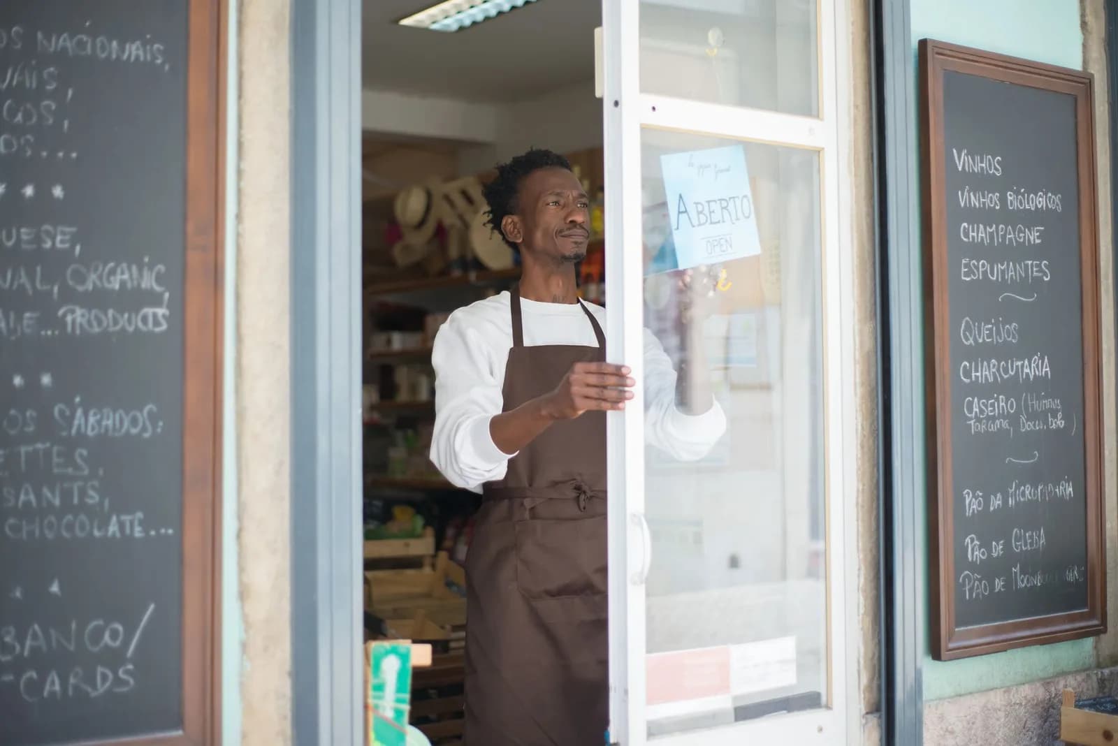 Comerciante em avental na porta de sua loja