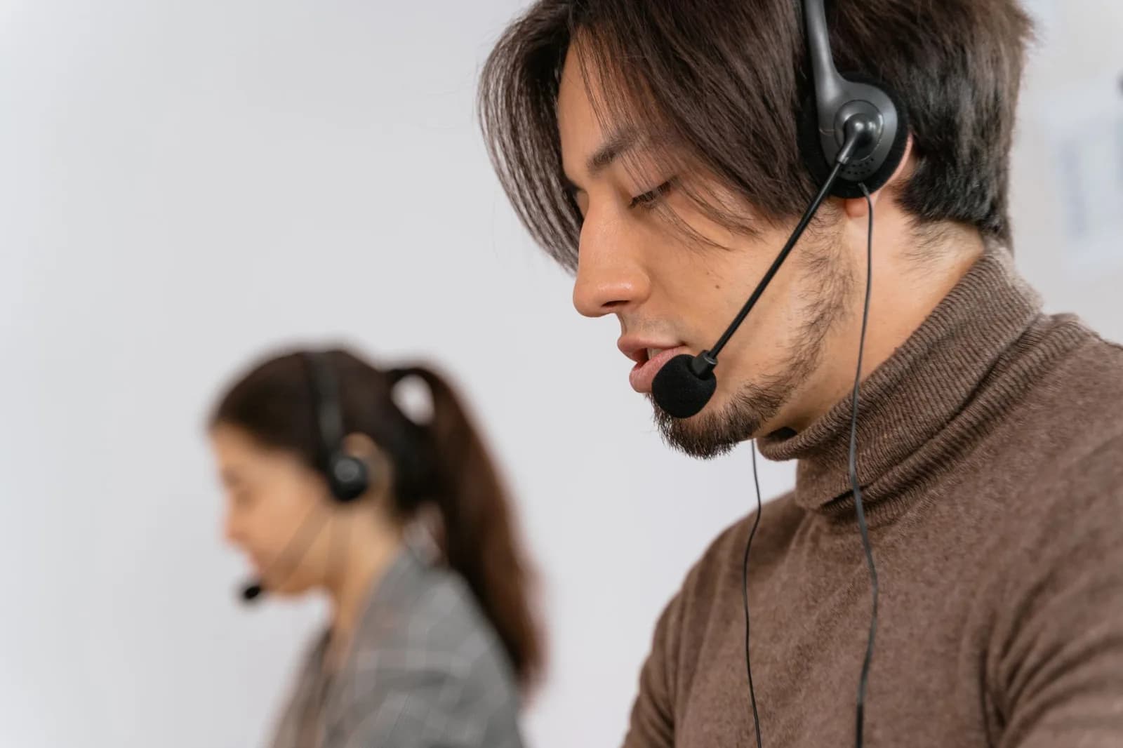 Operador de atendimento com fone e microfone em central telefônica