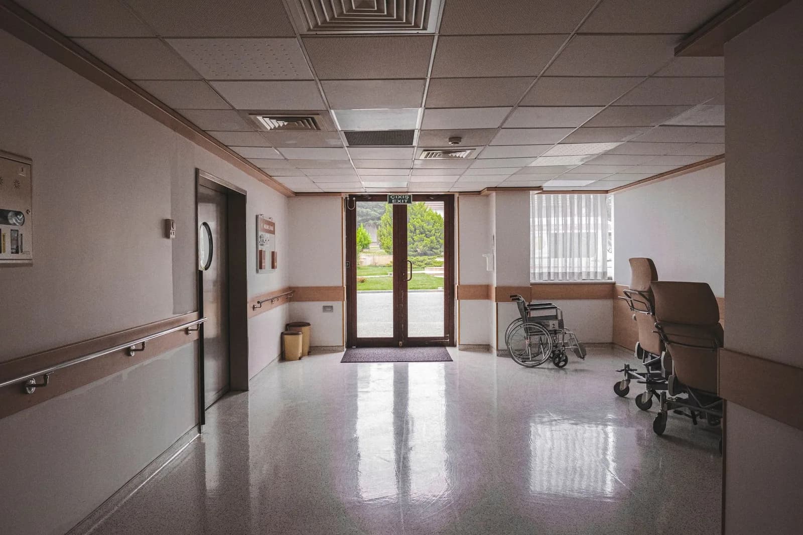 Corredor de hospital limpo, com cadeira de rodas ao fundo