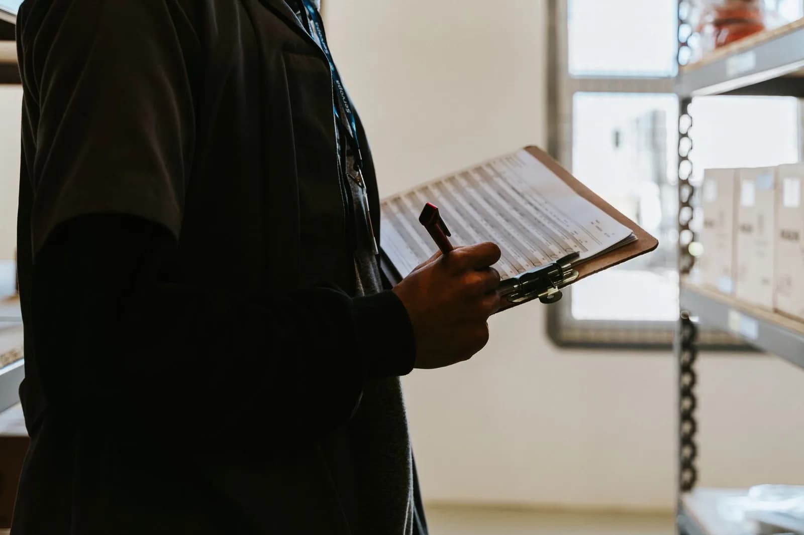 Trabalhador com prancheta confere itens em um depósito