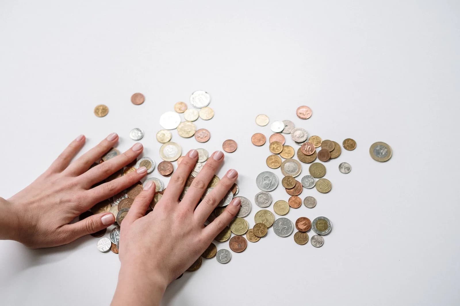 Mãos sobre moedas representando restituição do imposto de renda