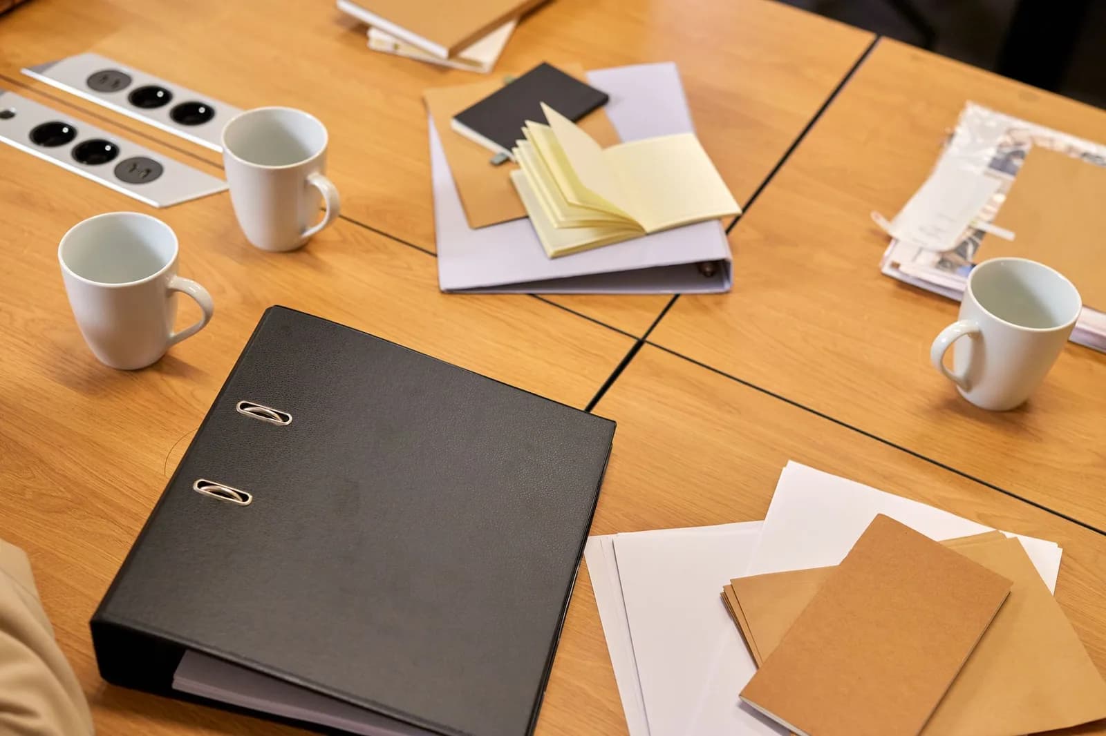 Pasta de documentos fechada sobre mesa de reunião corporativa