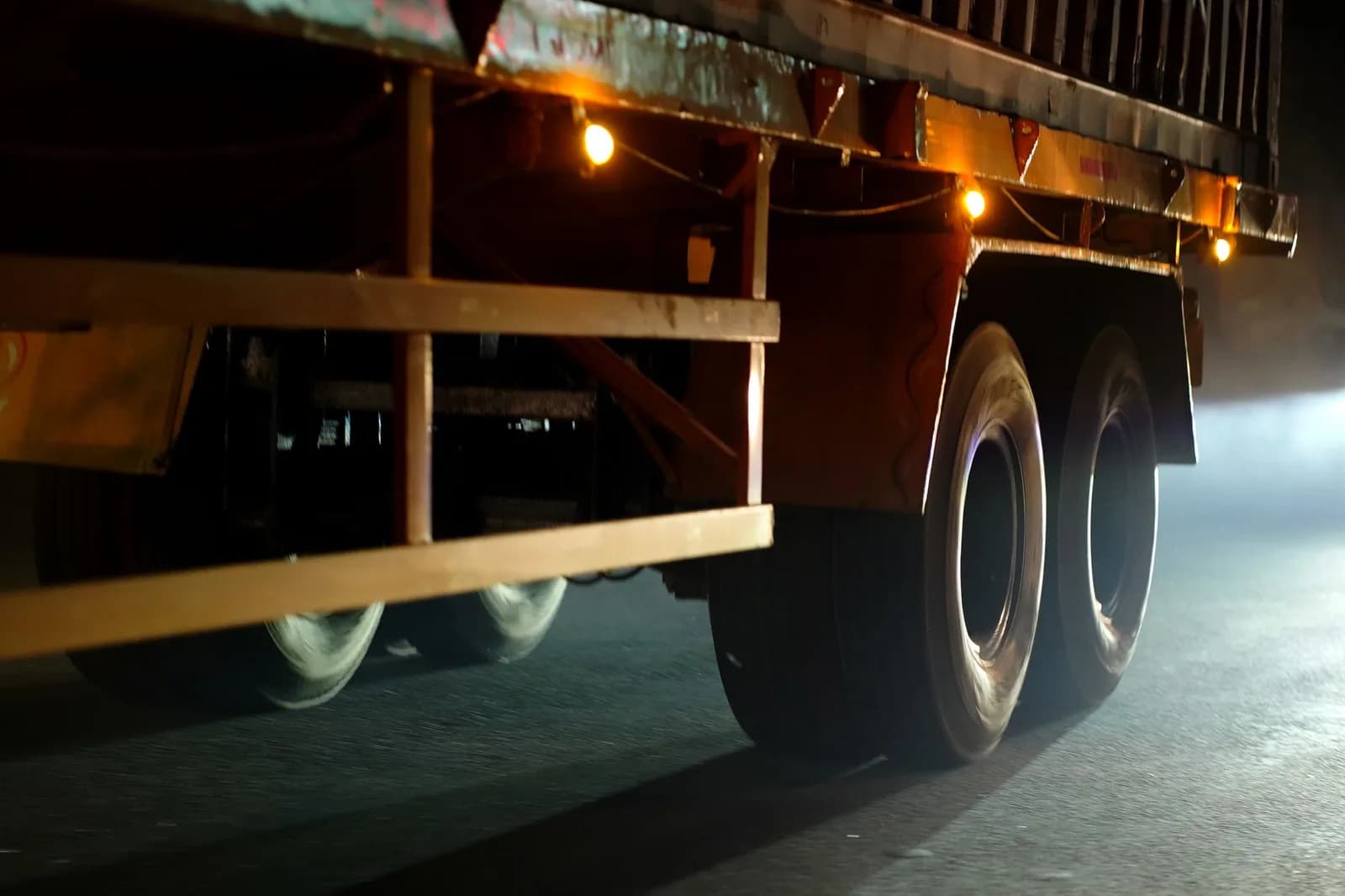 Lateral de caminhão com luzes acesas na estrada à noite