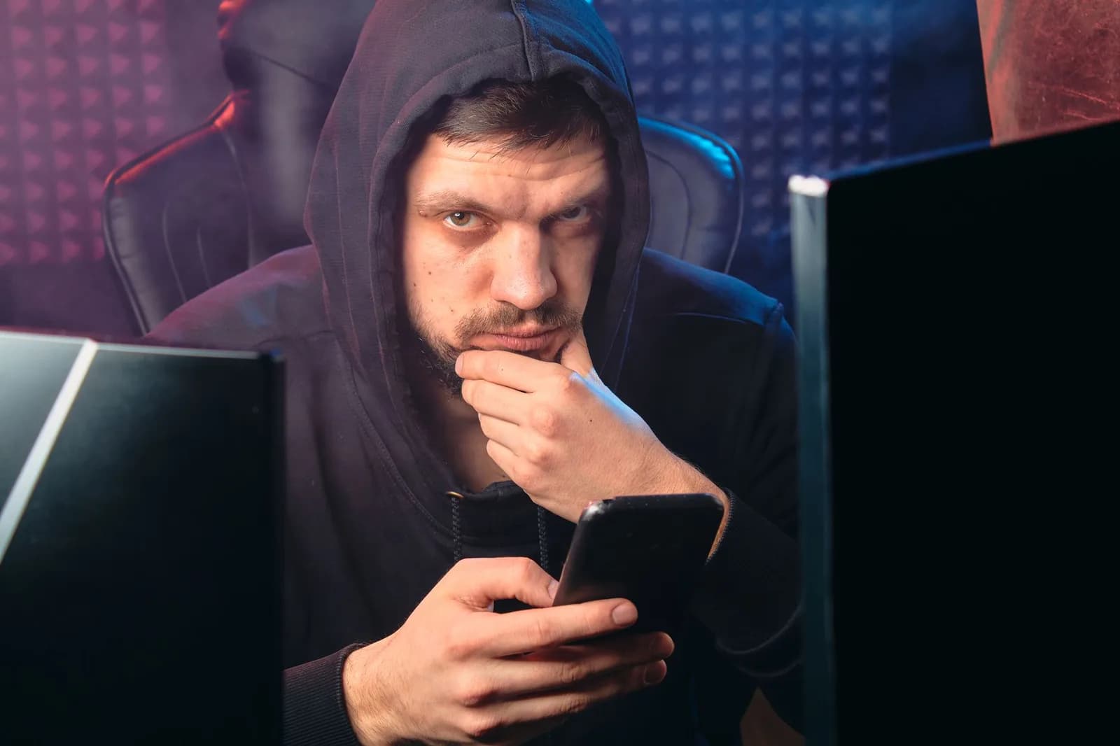 Homem de capuz olhando para o celular