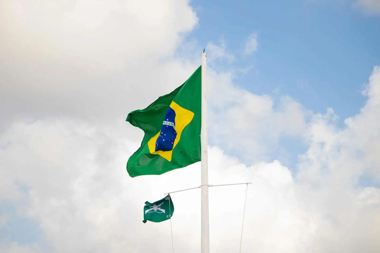 Bandeira do Brasil hasteada contra o céu azul