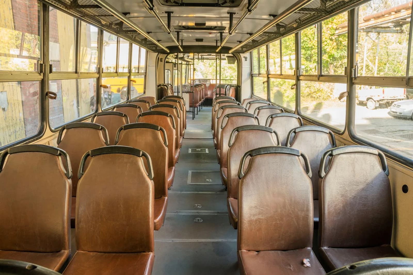Interior de um ônibus vazio, bancos alinhados