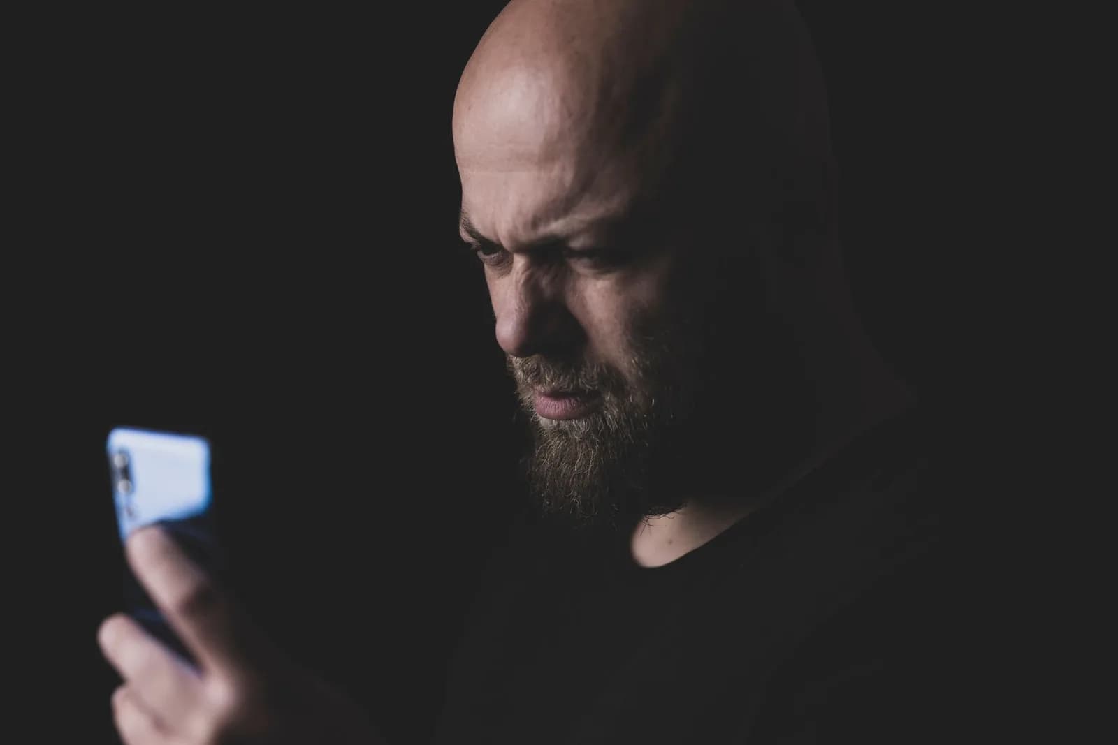 Investidor observando o celular com expressão séria