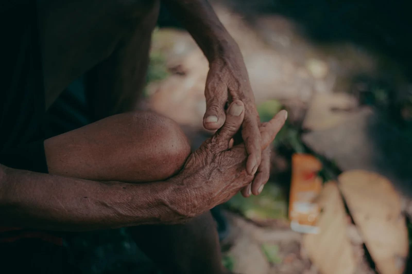 Mãos calejadas de um trabalhador idoso, marcadas por décadas de trabalho ao ar livre