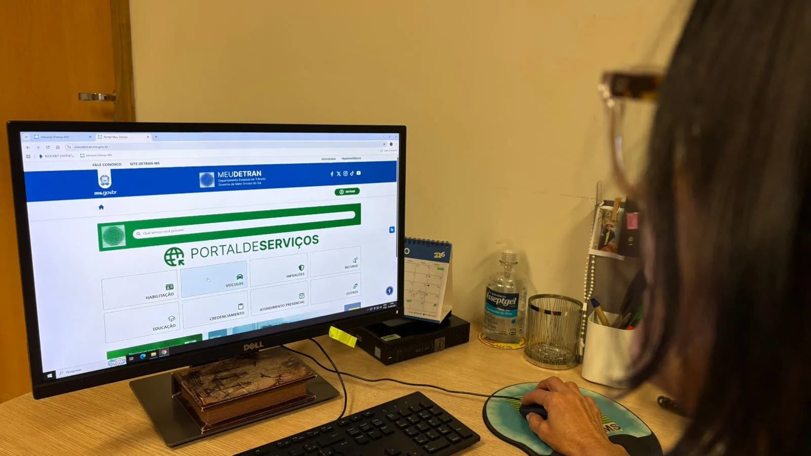 Atendente consulta o Portal Meu Detran MS na tela do computador