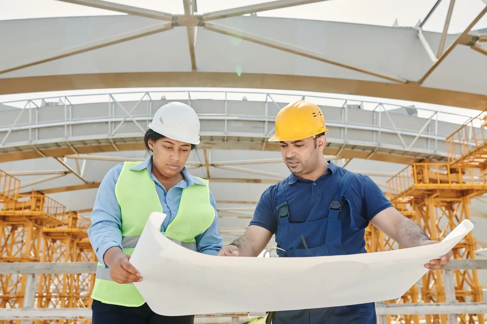 Dois trabalhadores com equipamento de proteção em canteiro de obras