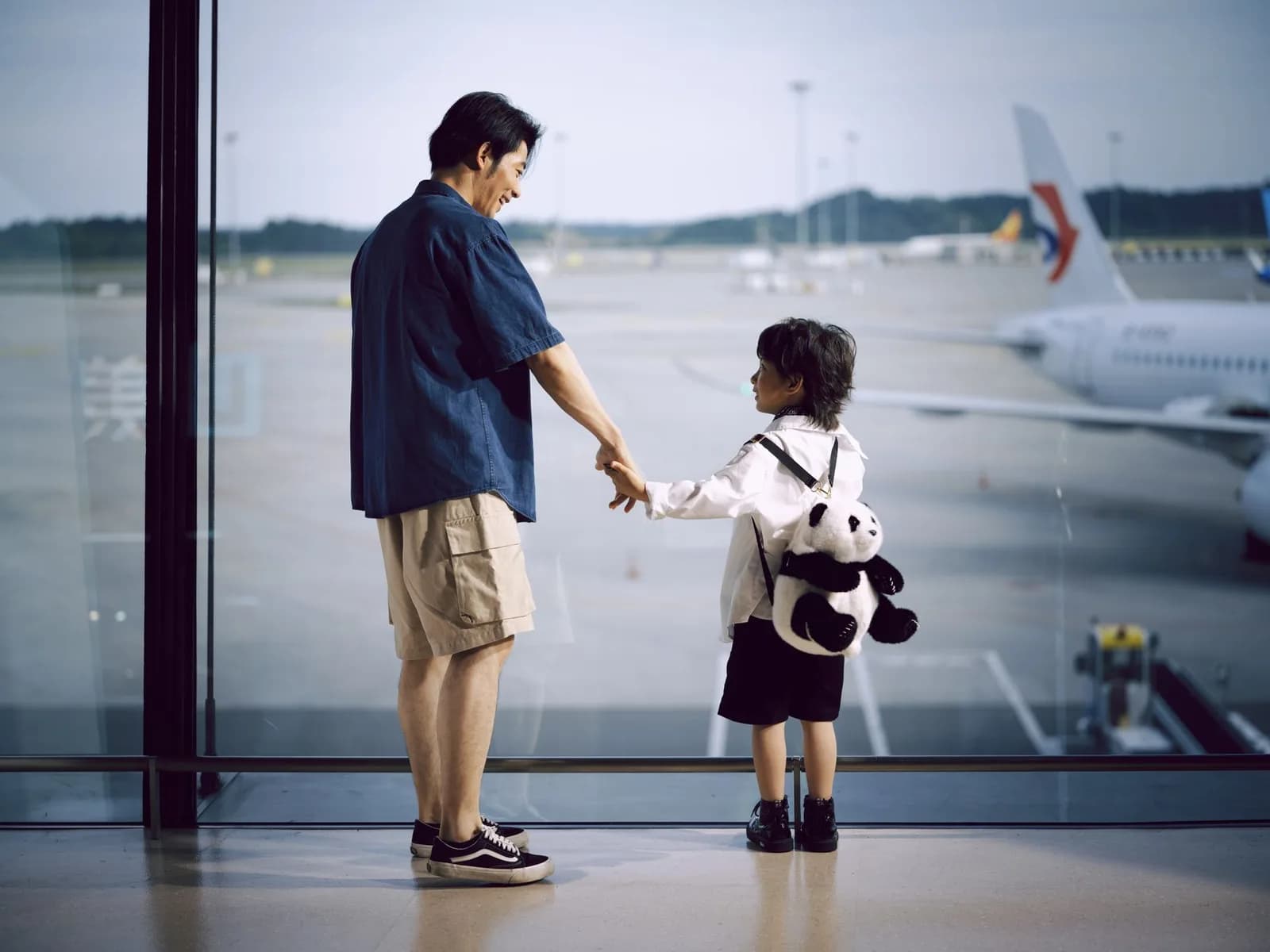 Adulto e criança observando as aeronaves no aeroporto