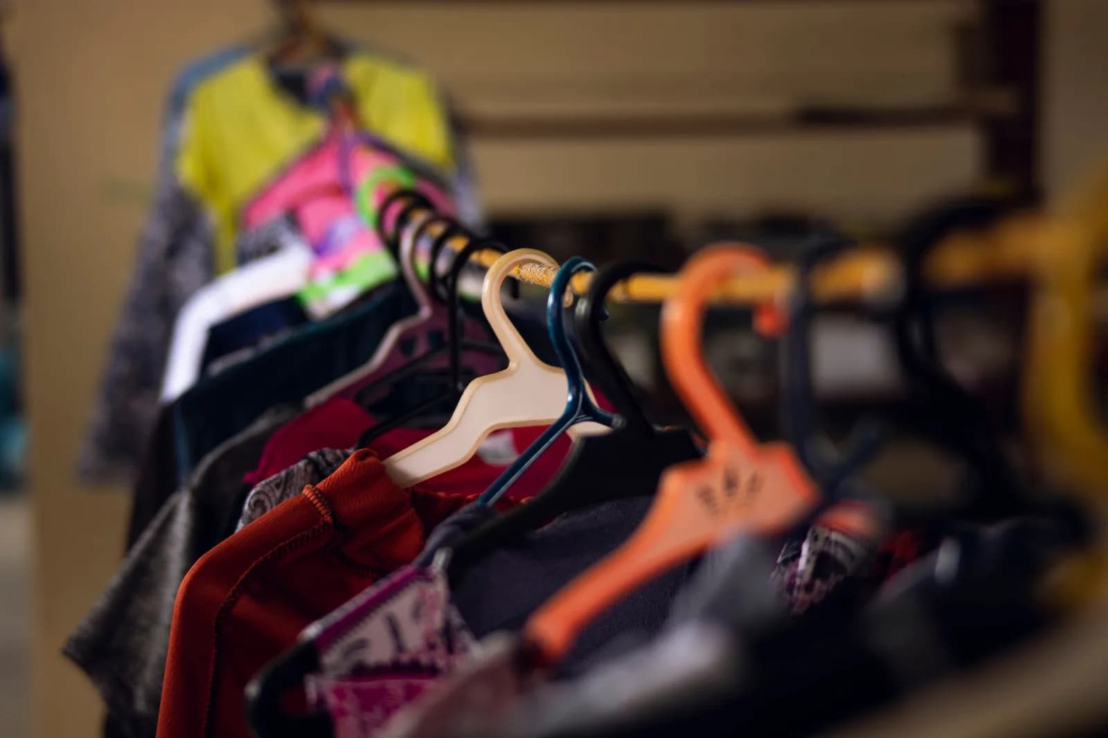 Araras cheias de roupas variadas em um brechó