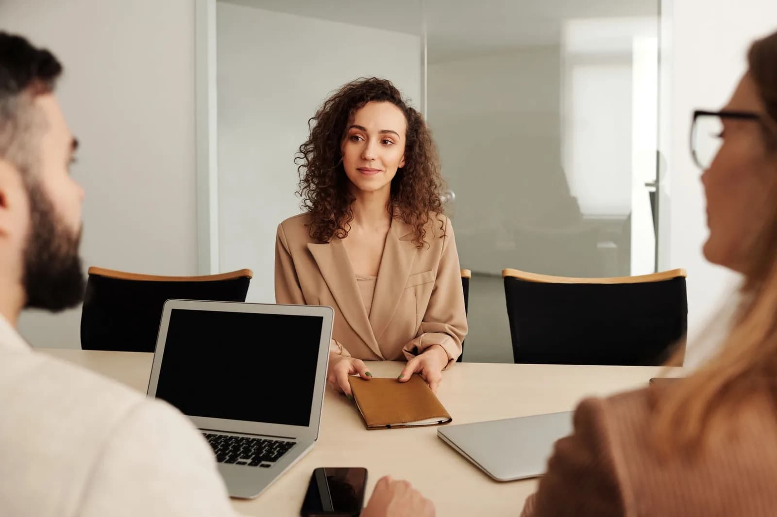Candidata é entrevistada por recrutadores em mesa com laptop