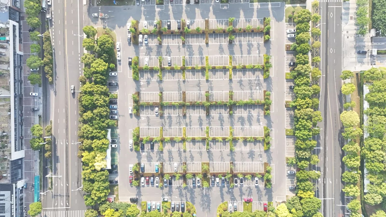 Vista aérea de um estacionamento organizado com fileiras de carros