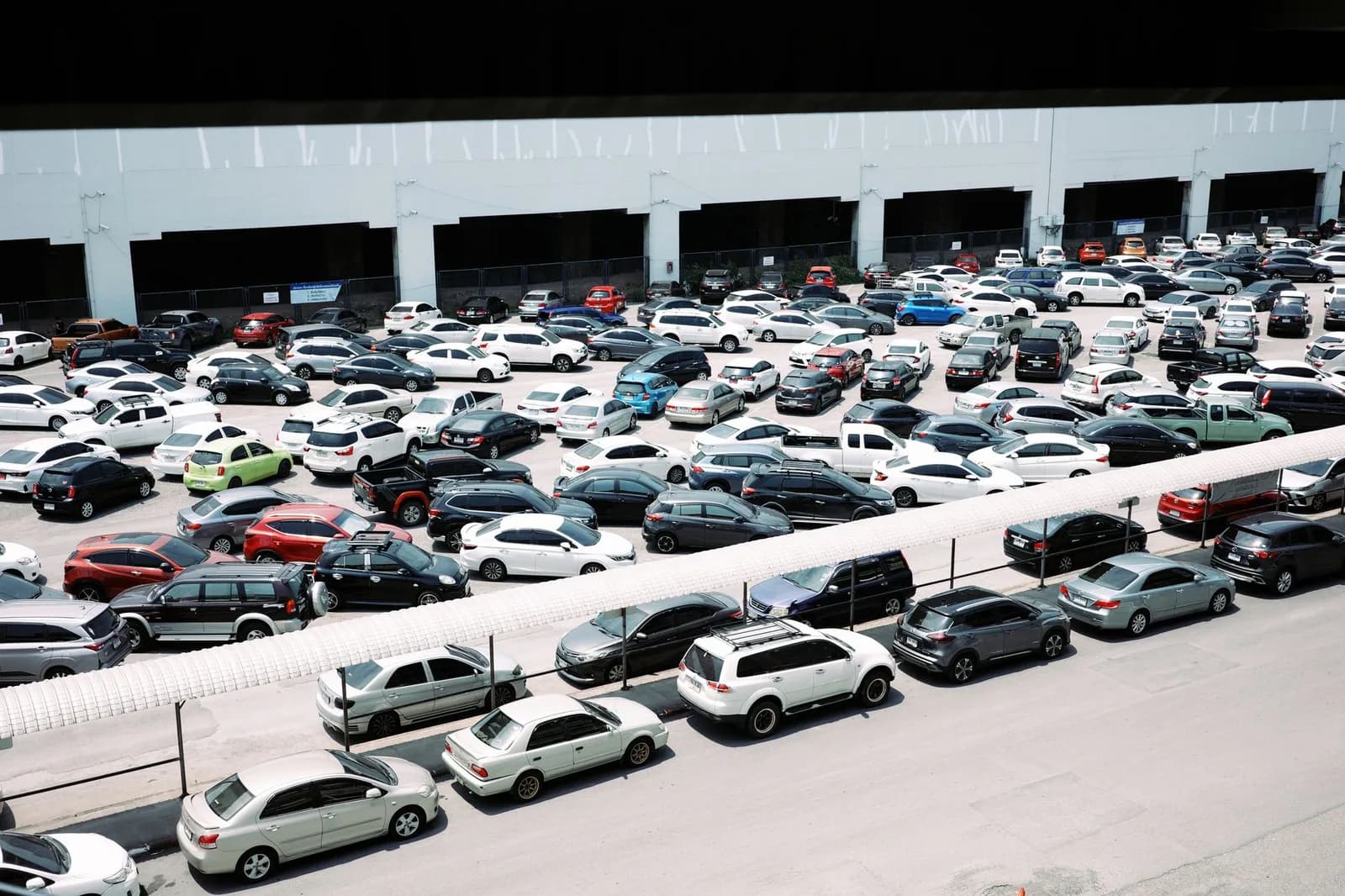 Patio aberto com dezenas de carros e automoveis recolhidos organizados em fileiras para leilao