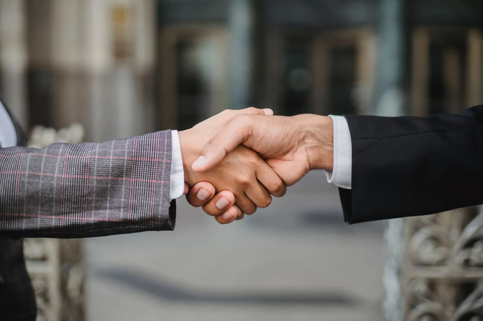 Aperto de mãos entre dois executivos em ambiente de negócios.