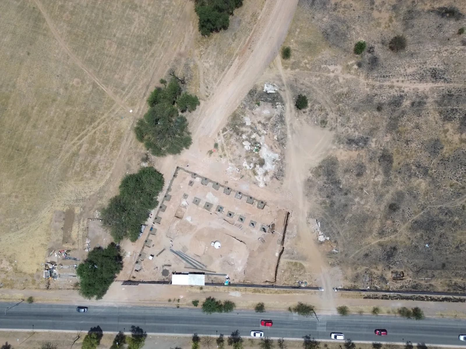Vista aérea de terreno com estrada e área cercada em construção